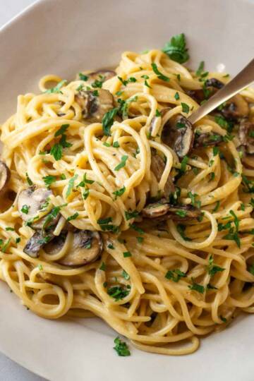 a plate with lactose free mushroom carbonara sprinkled with parsley