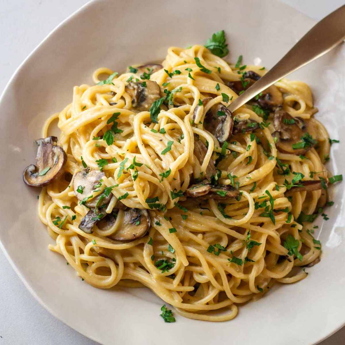 a plate with lactose free mushroom carbonara sprinkled with parsley