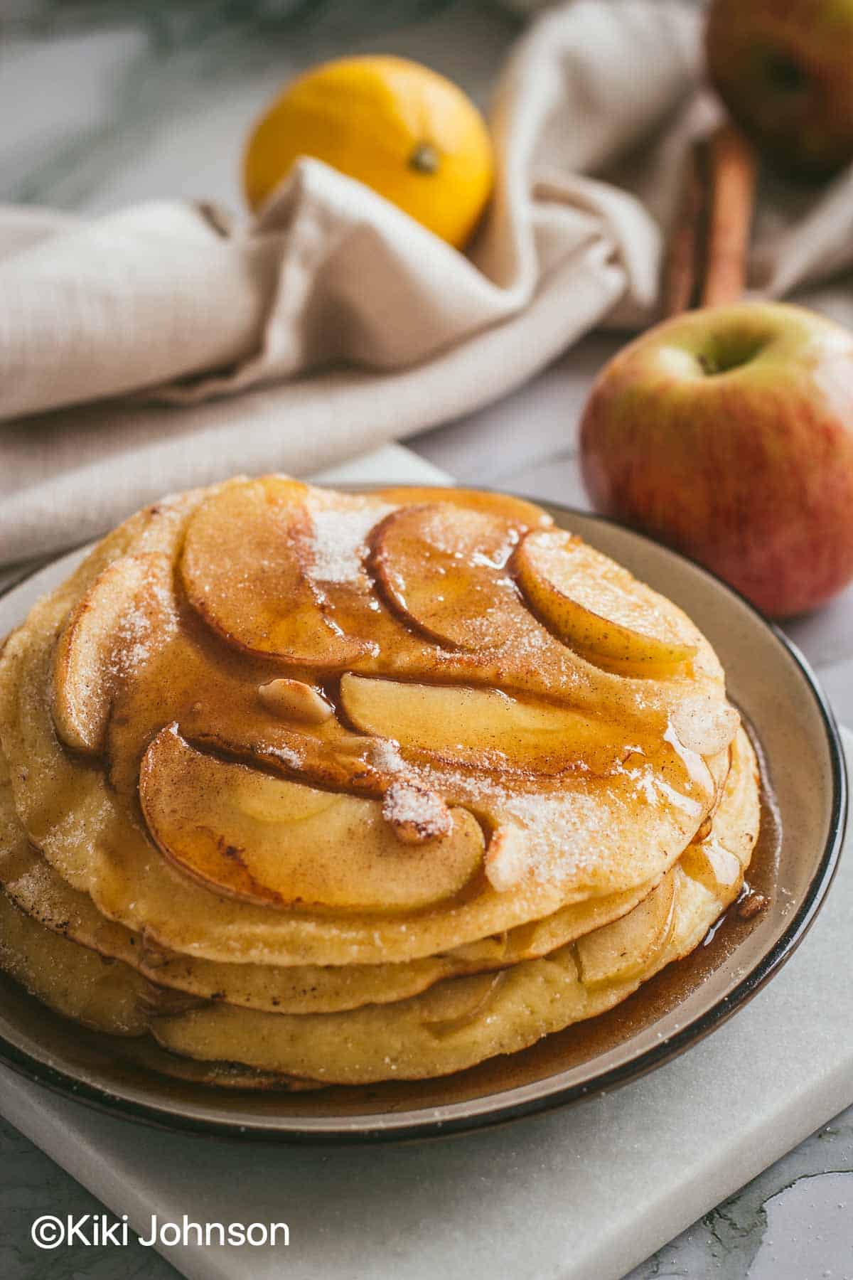 a stack of grannys pancakes with fresh apples on a plate