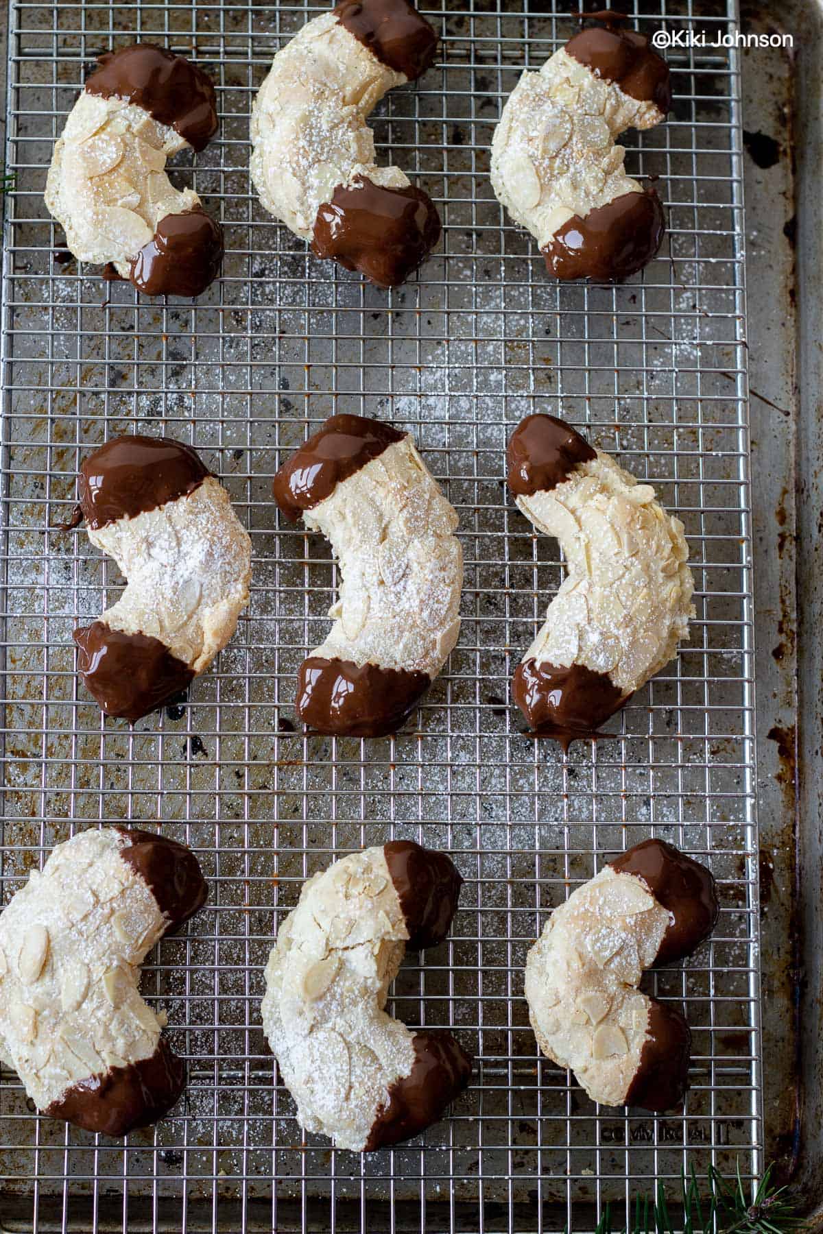 frisch gebackene Marzipan Mandelhörnchen mit Mandelblättchen auf einem Kuchengitter 