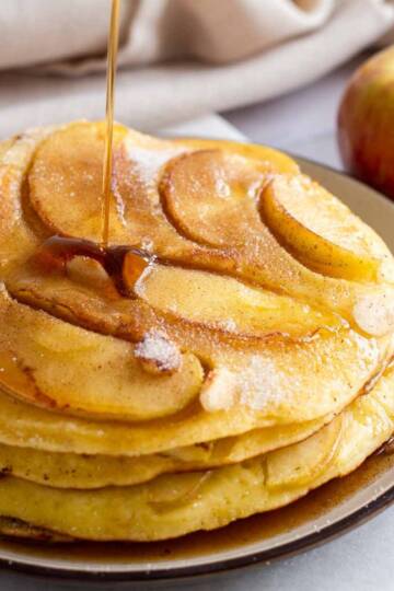 a stack of grannys german apple pancakes drizzled with maple syrup