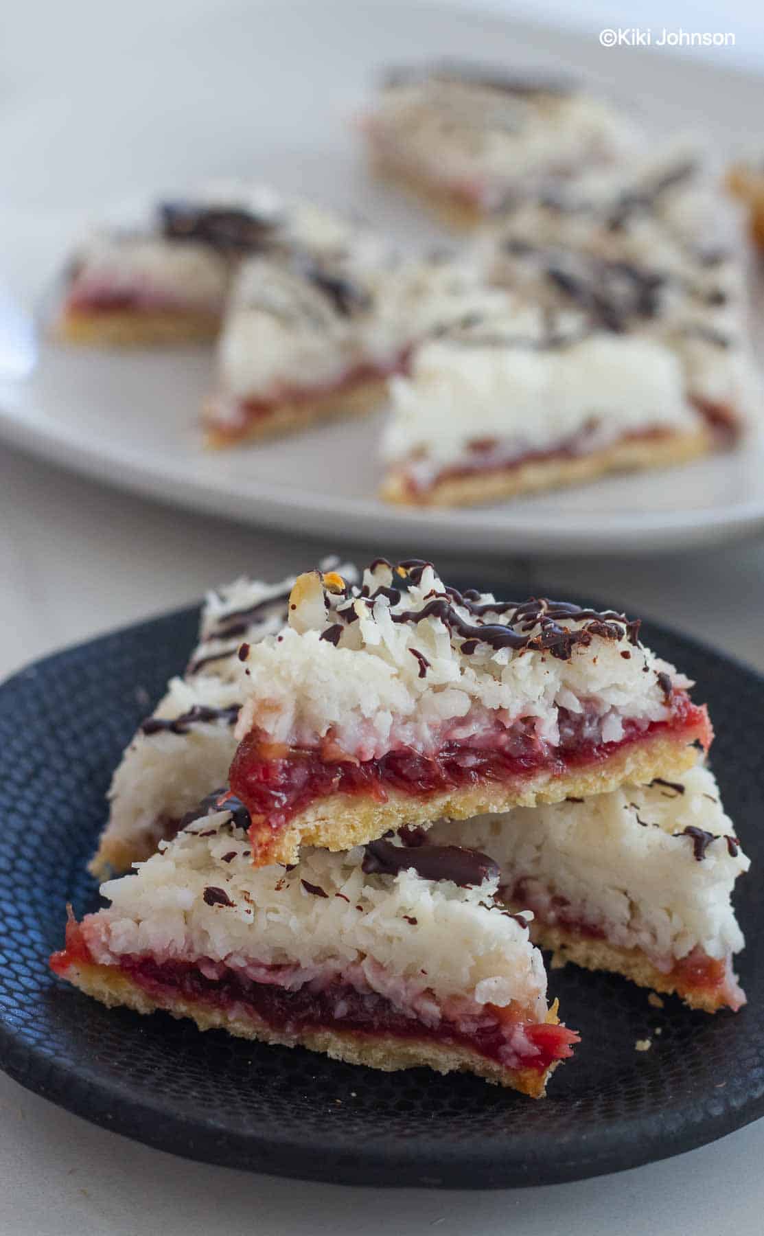 saftige Kokosecken mit Marzipan auf einem kleinen schwarzen Teller 