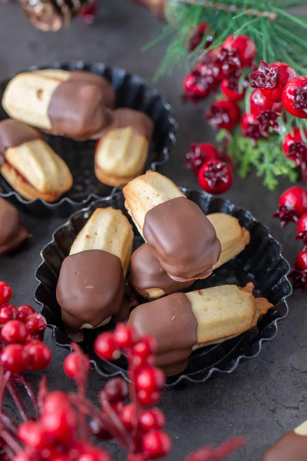 two small bowls with Austrian Spritz Cookies with Jam and coated with chocolate
