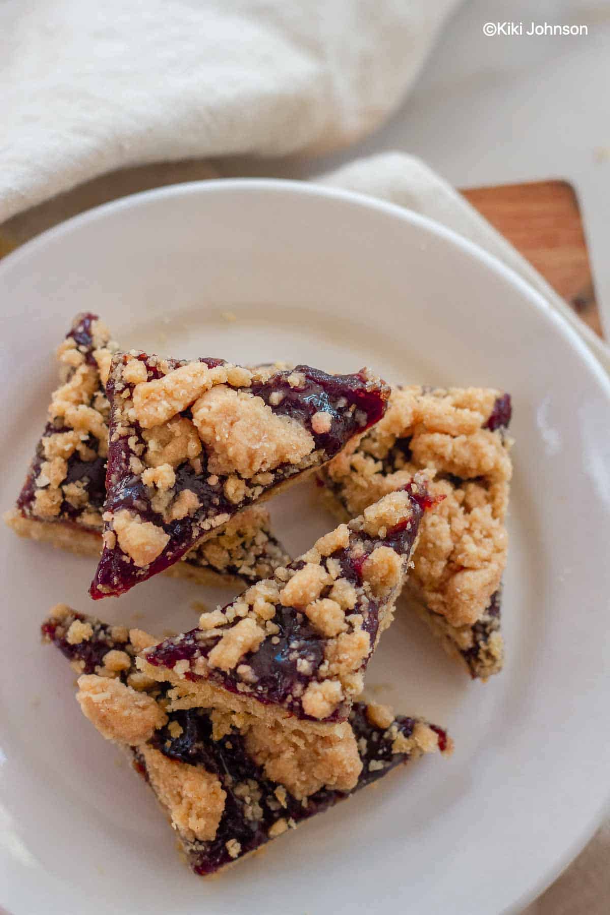 Rautenförmige Plätzchen mit Pflaumenmus und Zimt Mandeln Streusel auf einem weißen Teller 