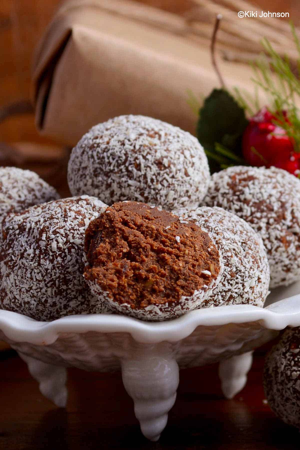 German Rum Balls rolled in shredded coconut flakes on a small cake stand 