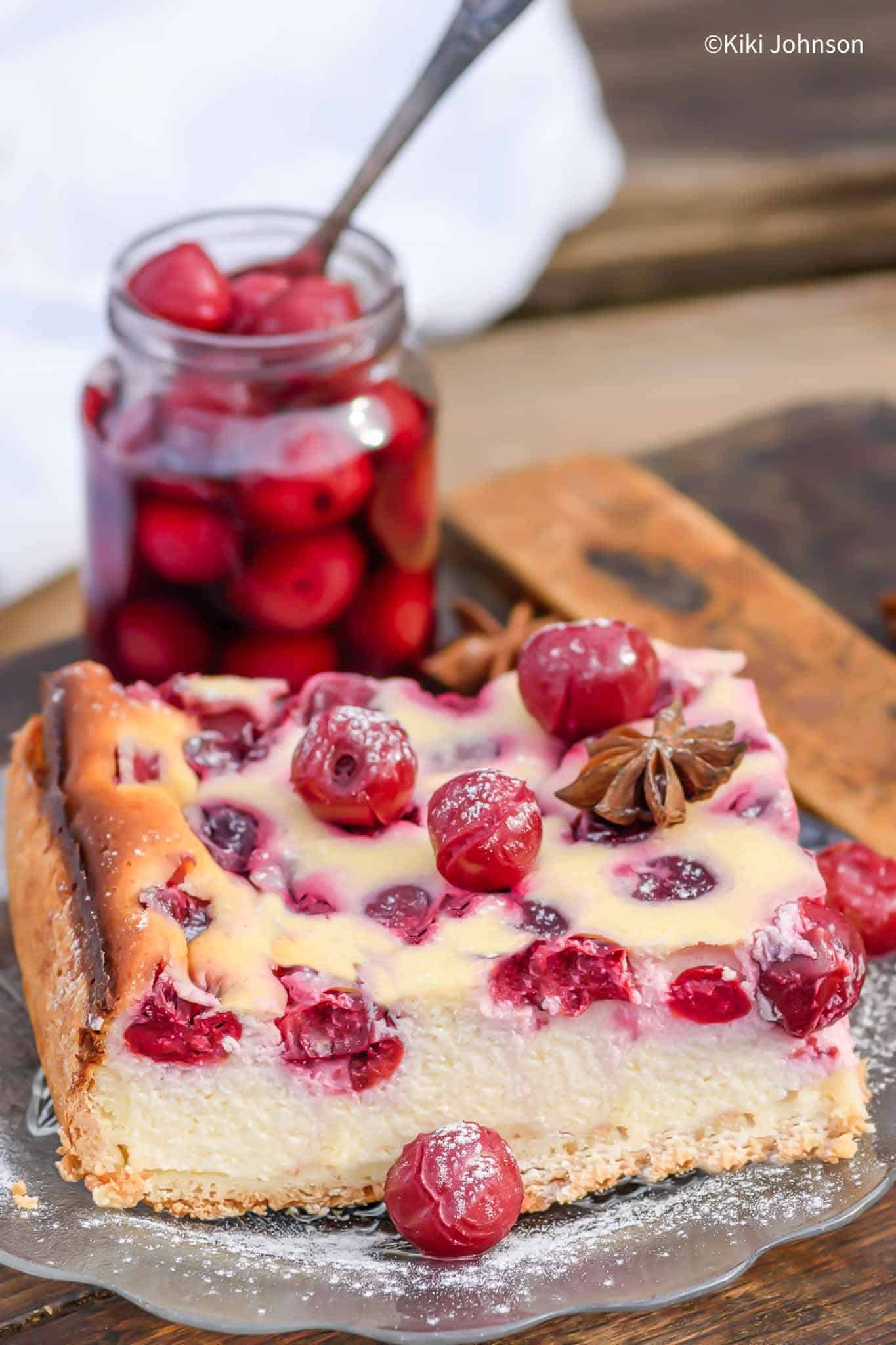 a slice of German Cherry Cheesecake topped with sour cherries 