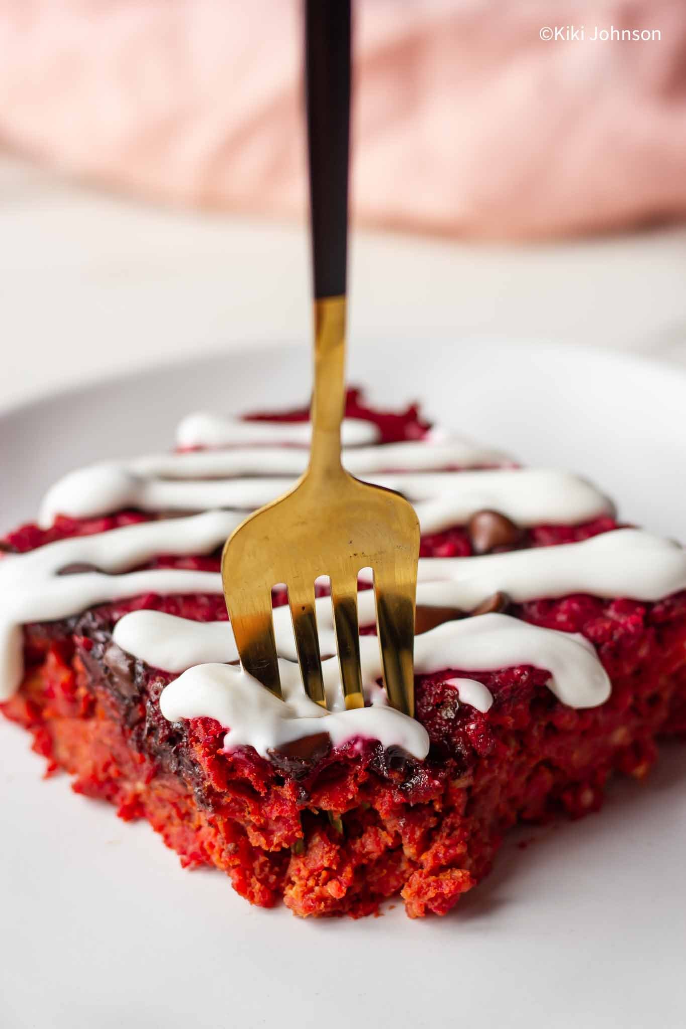 a golden fork digging into a square of high protein beet oatmeal bake 