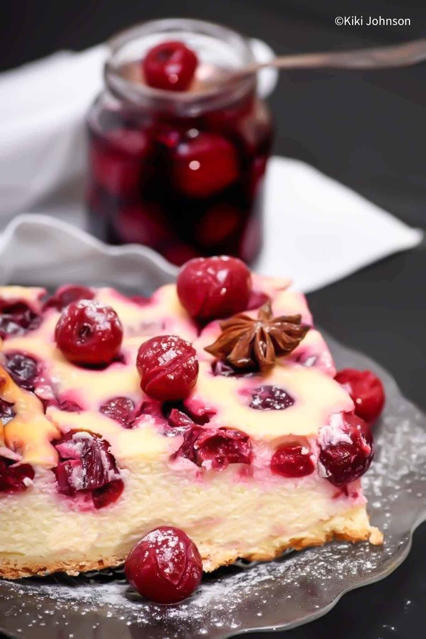 a square piece of sheet pan German Cheesecake topped with sour cherries 