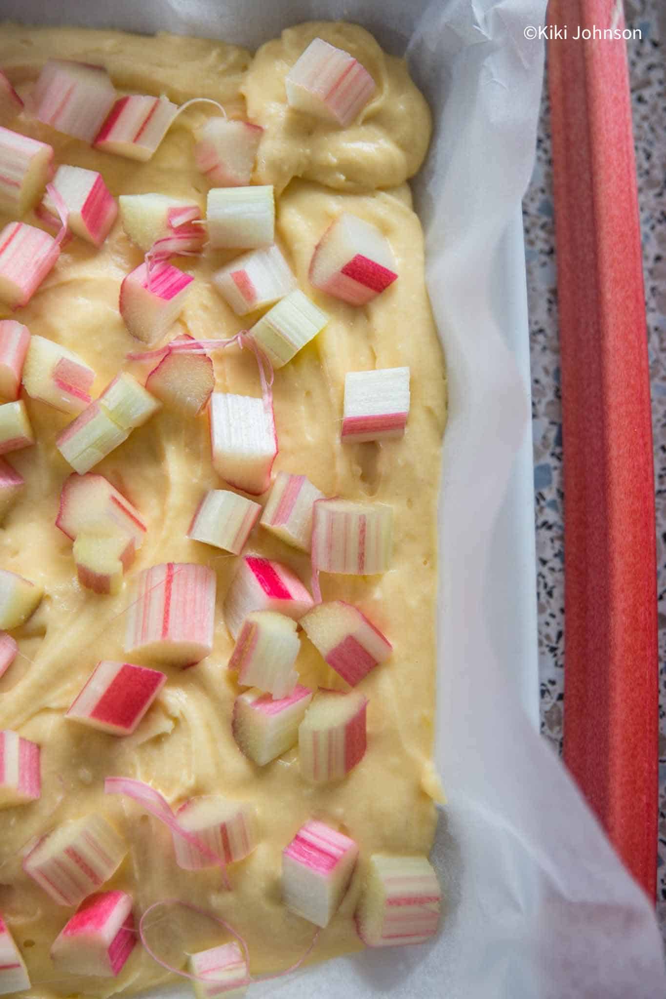 Marzipan Rührteig auf einem Blech mit frischen Rhabarberscheiben belegt