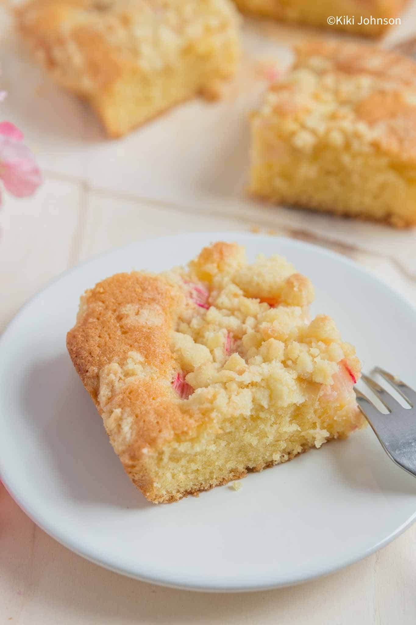 a piece of German Rhubarb Tray Bake with Streusel topping on a white cake plate