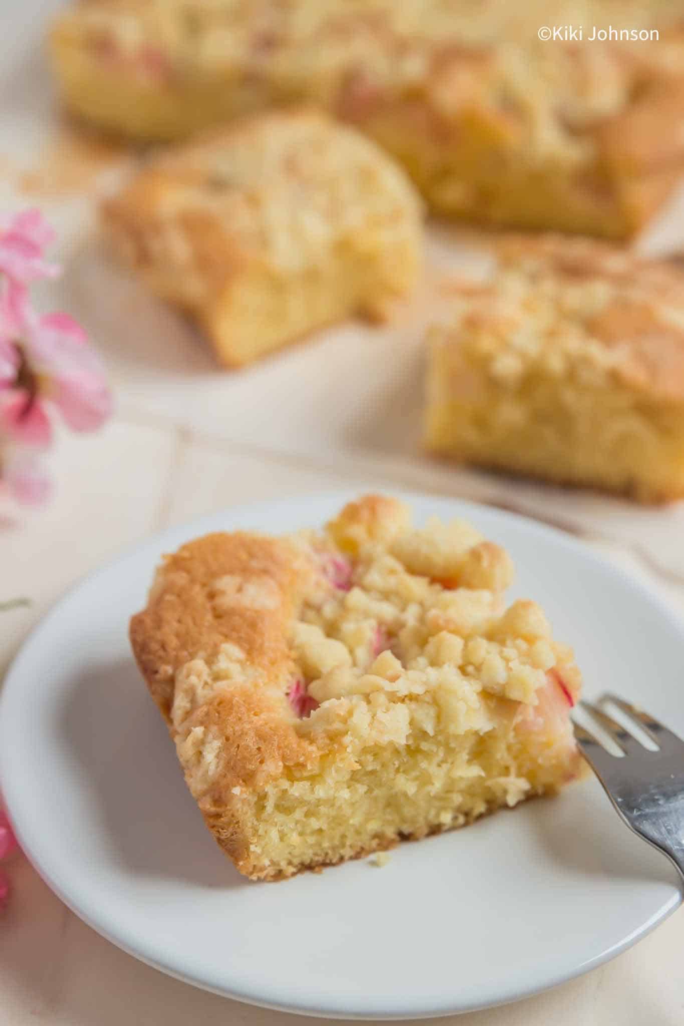 a piece of Rhubarb Crumble Traybake on a Cake plate with a fork on the side 