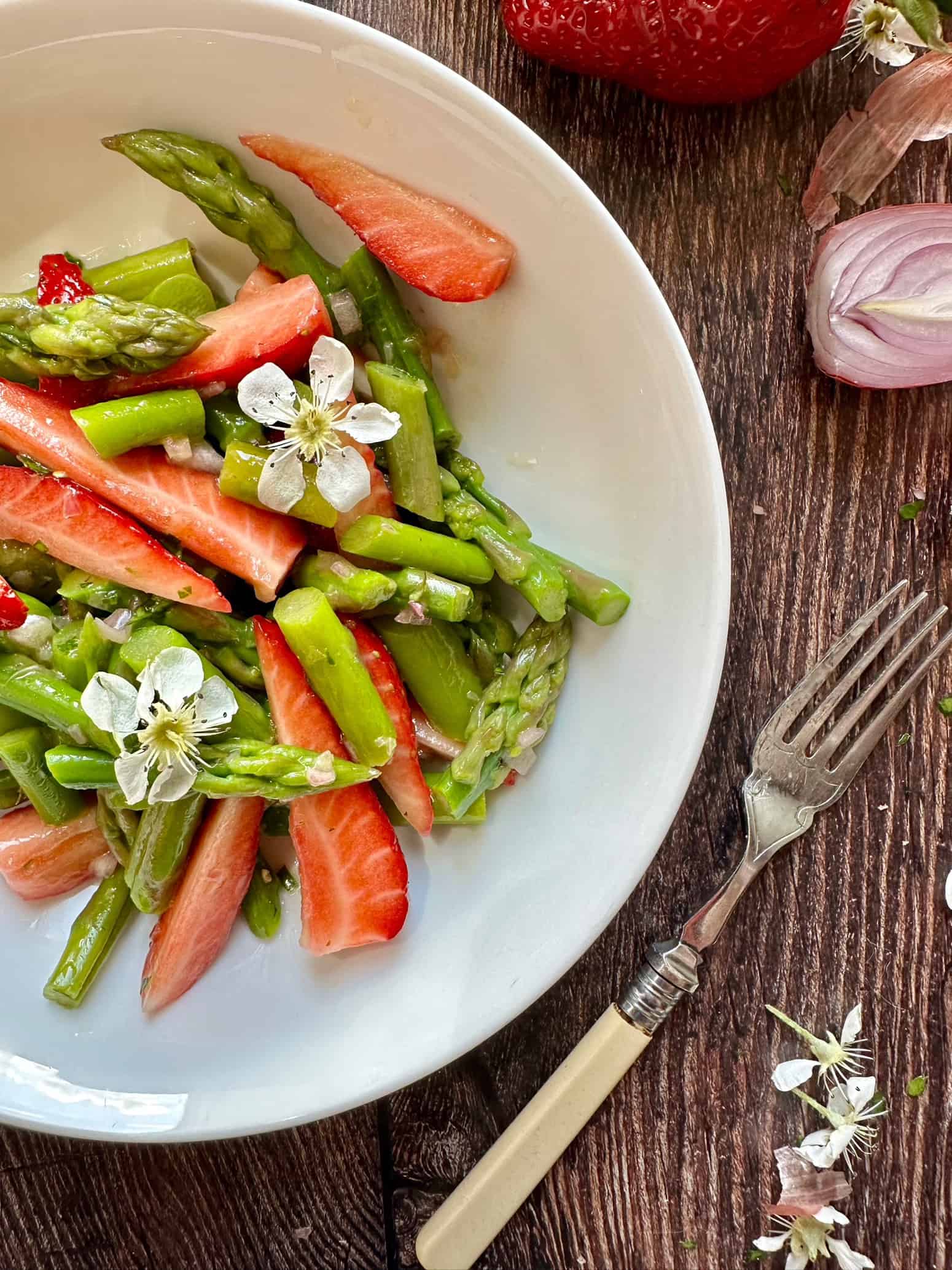 eine Schale mit grünem Spargel Salat mit frischen Erdbeeren. 