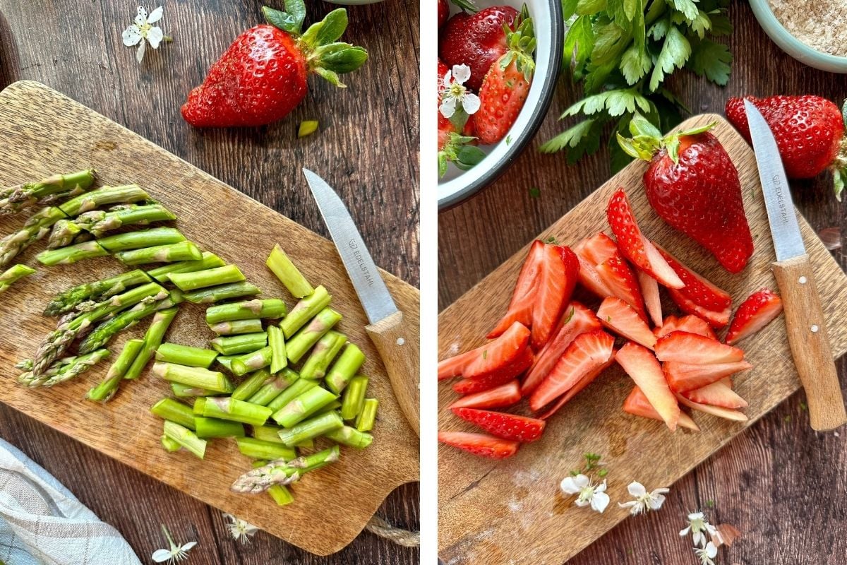 grüner Spargel und Erdbeeren werden auf einem Holzbrett in Stücke geschnitten. 