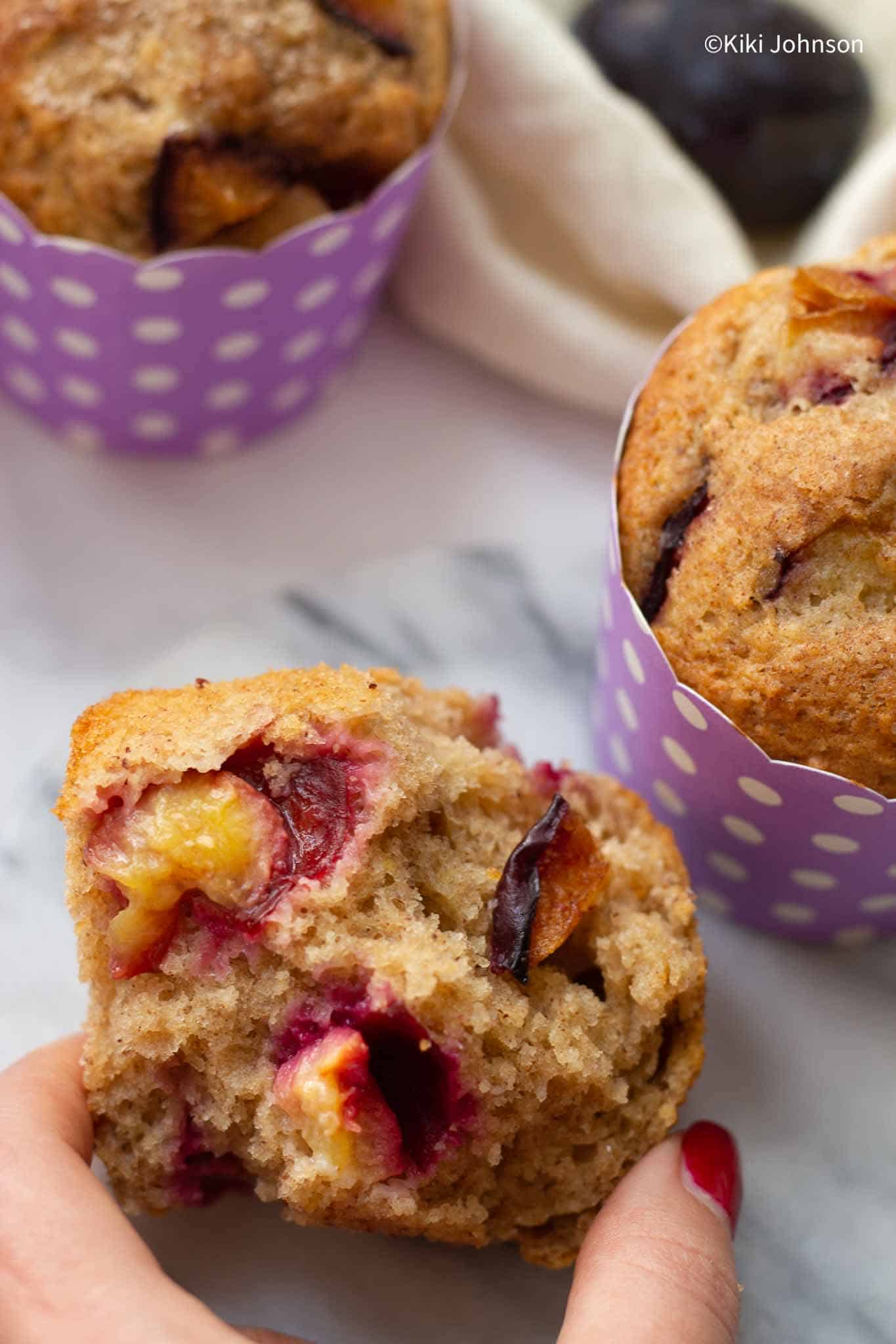 a halved German plum muffin with juicy chunks of plums in the batter.
