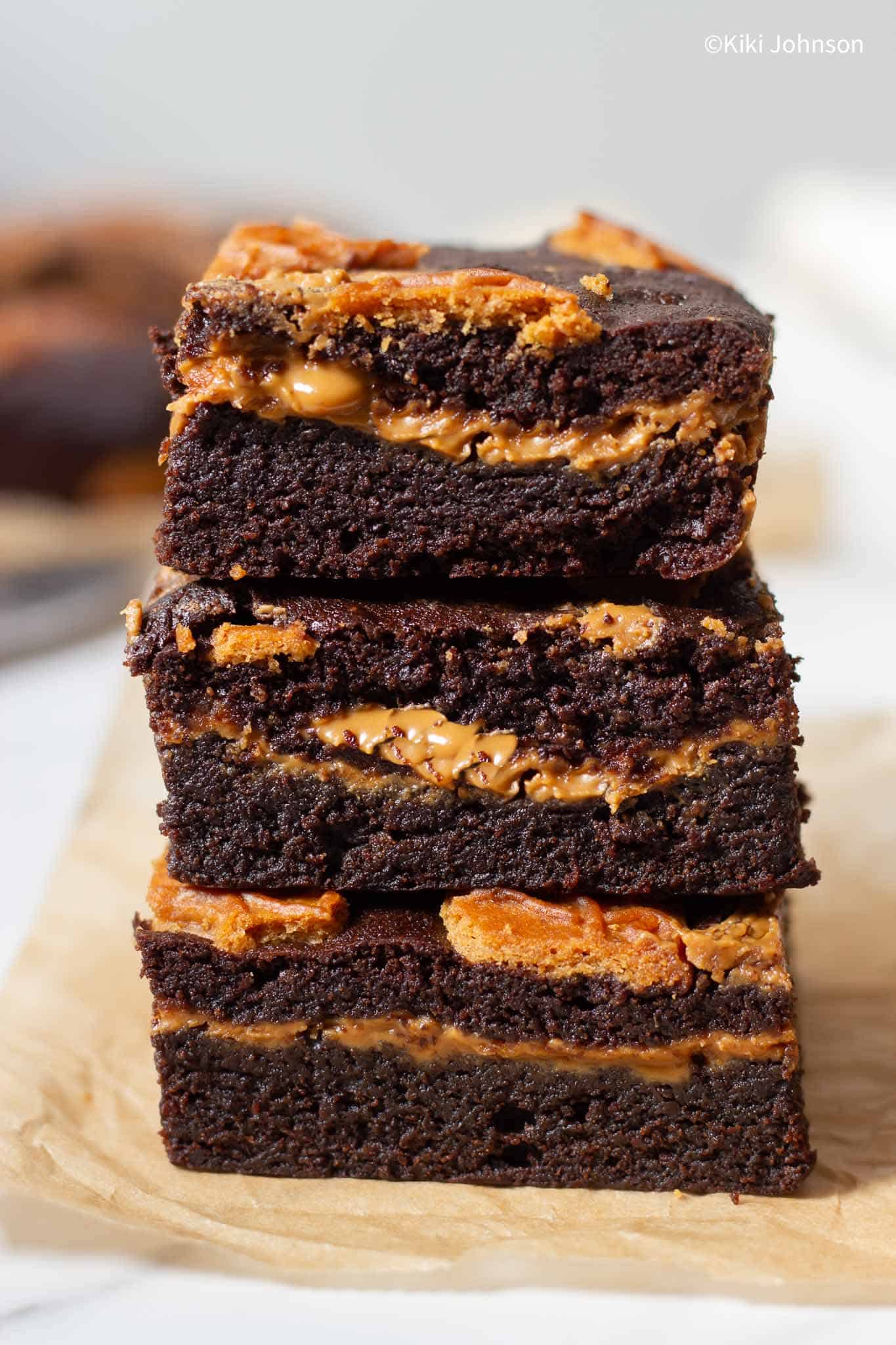 a stack of Biscoff Brownies filled with cookie butter and topped with lotus cookies.