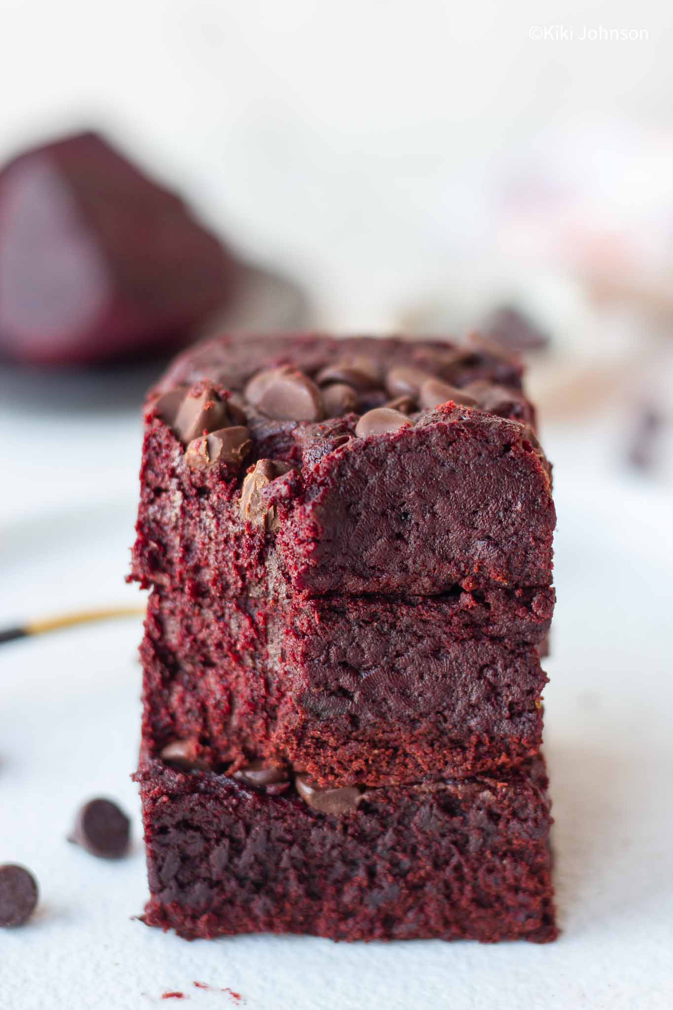 three stacked vegan beetroot brownies topped with chocolate chips