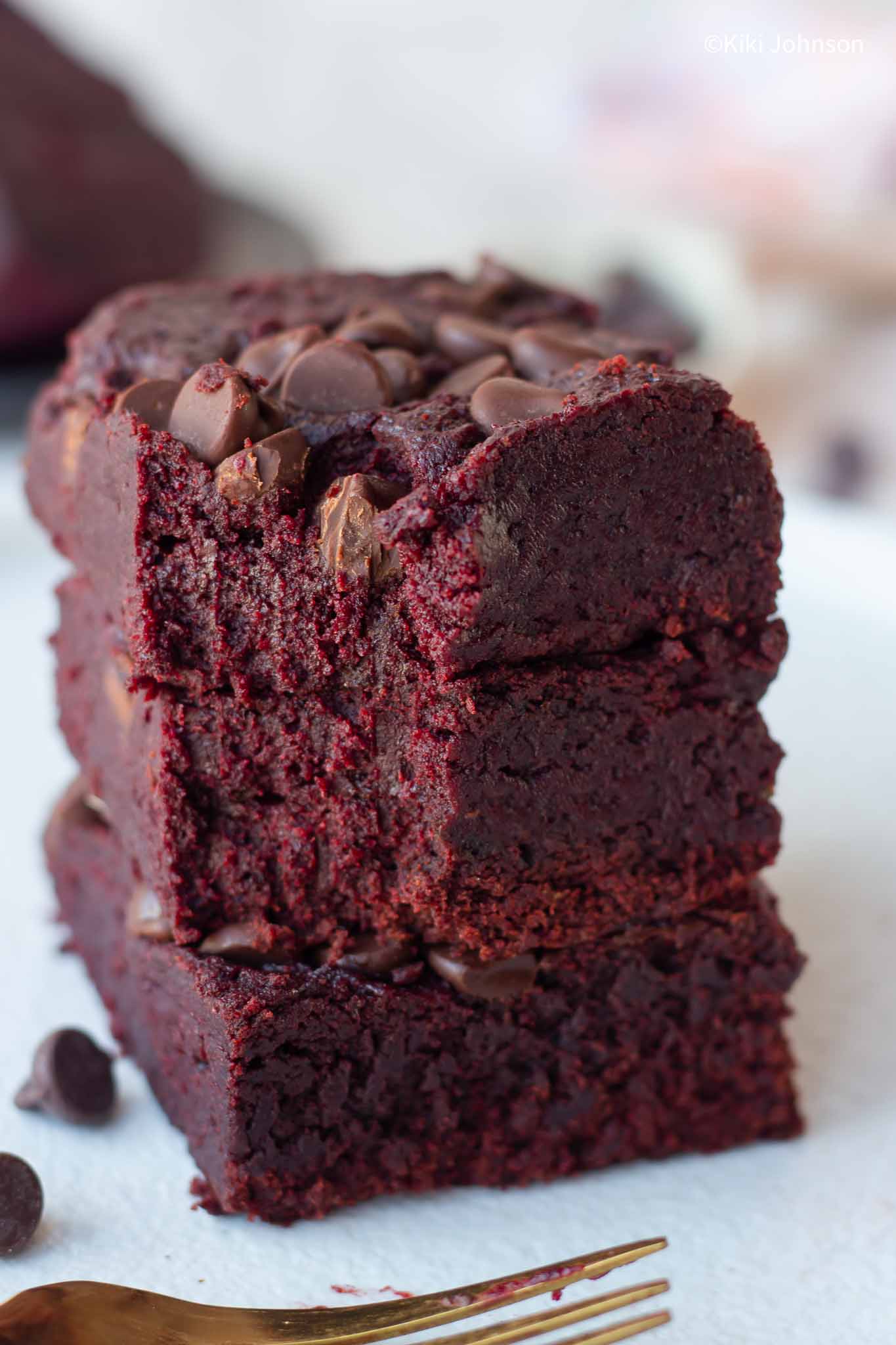 three stacked vegan beet brownies with chocolate chips on top