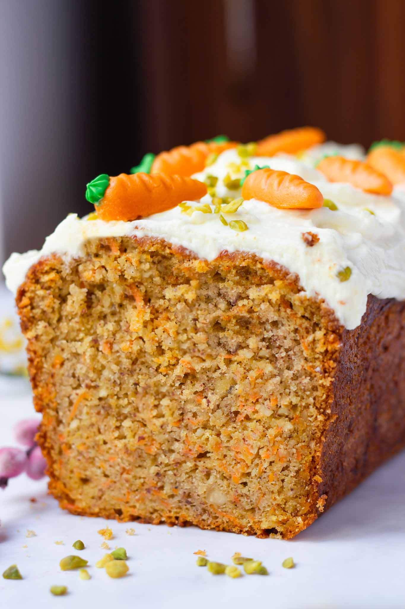 half a Swiss German carrot loaf cake topped with cream cheese frosting