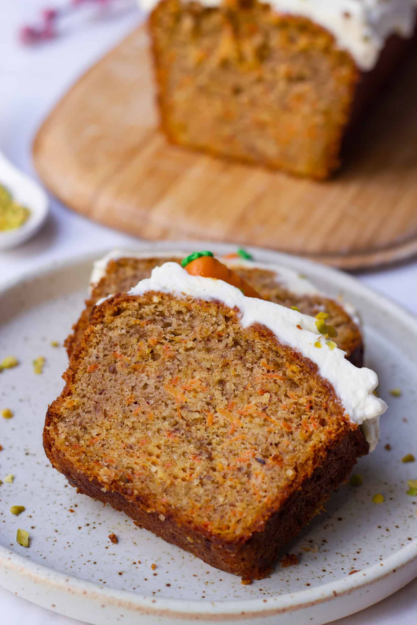 two slices of Swiss German Carrot Cake with a loaf pan in the background