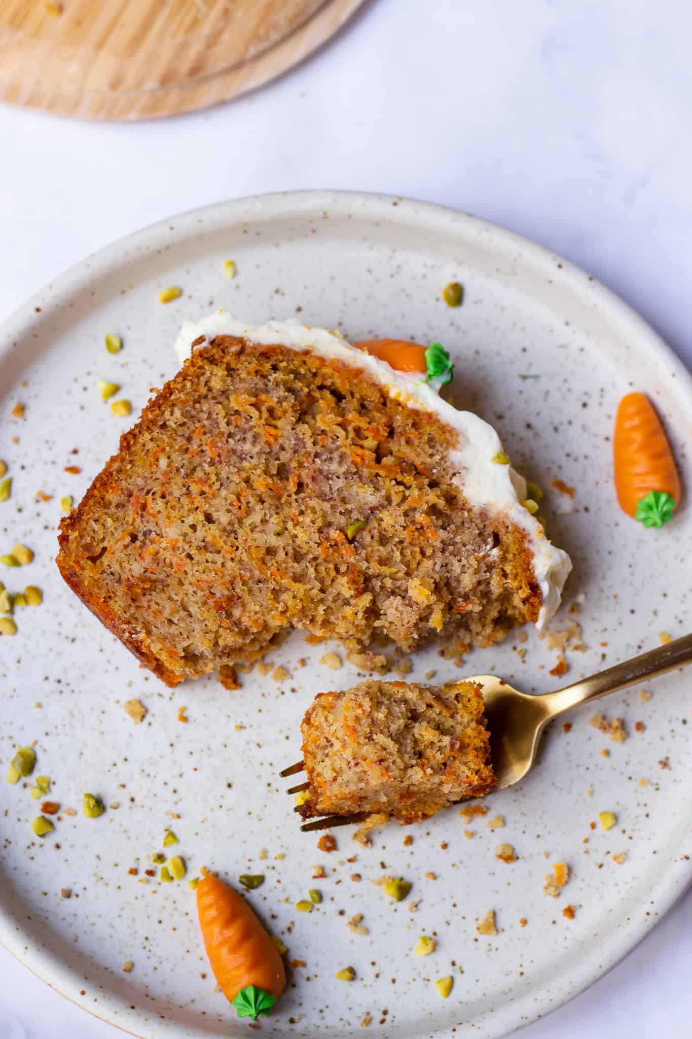a slice of Swiss German Carrot cake with cream cheese frosting marzipan carrots