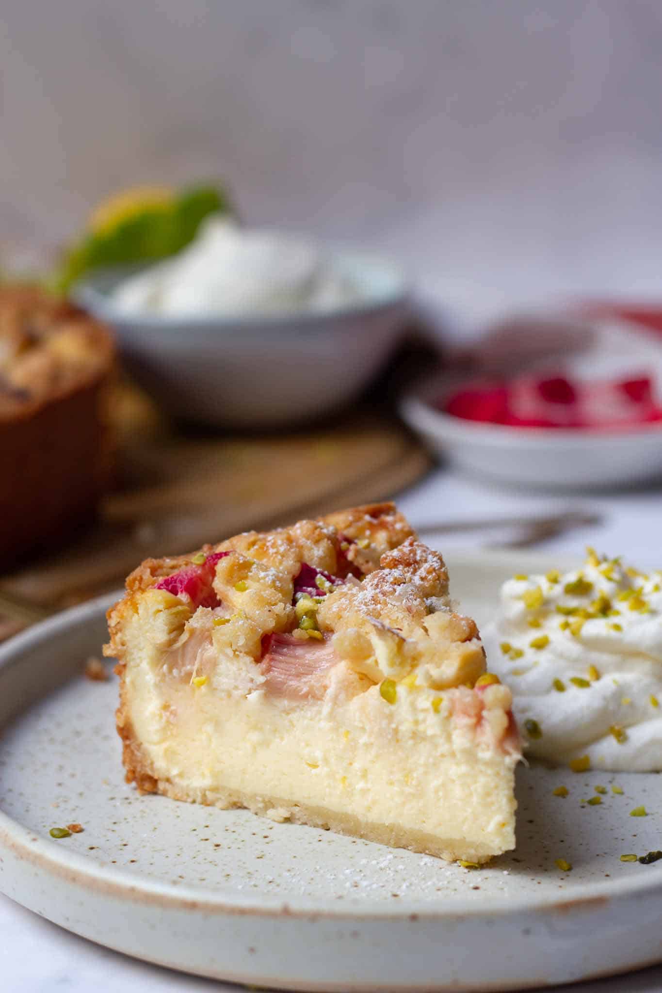 A piece of German rhubarb quark cake with streusel and pistachios.