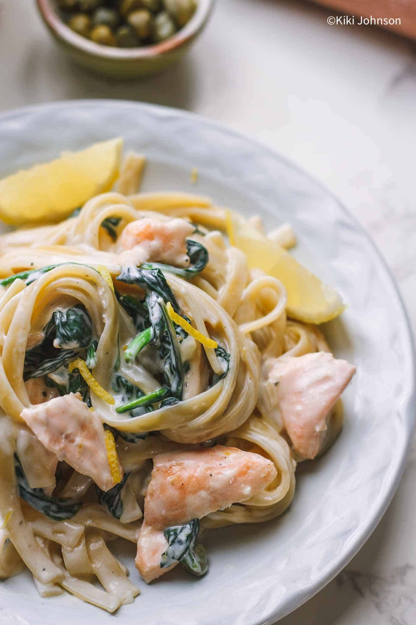 Nahaufnahme von Lachs Pasta mit Spinach und Zitronenschale.