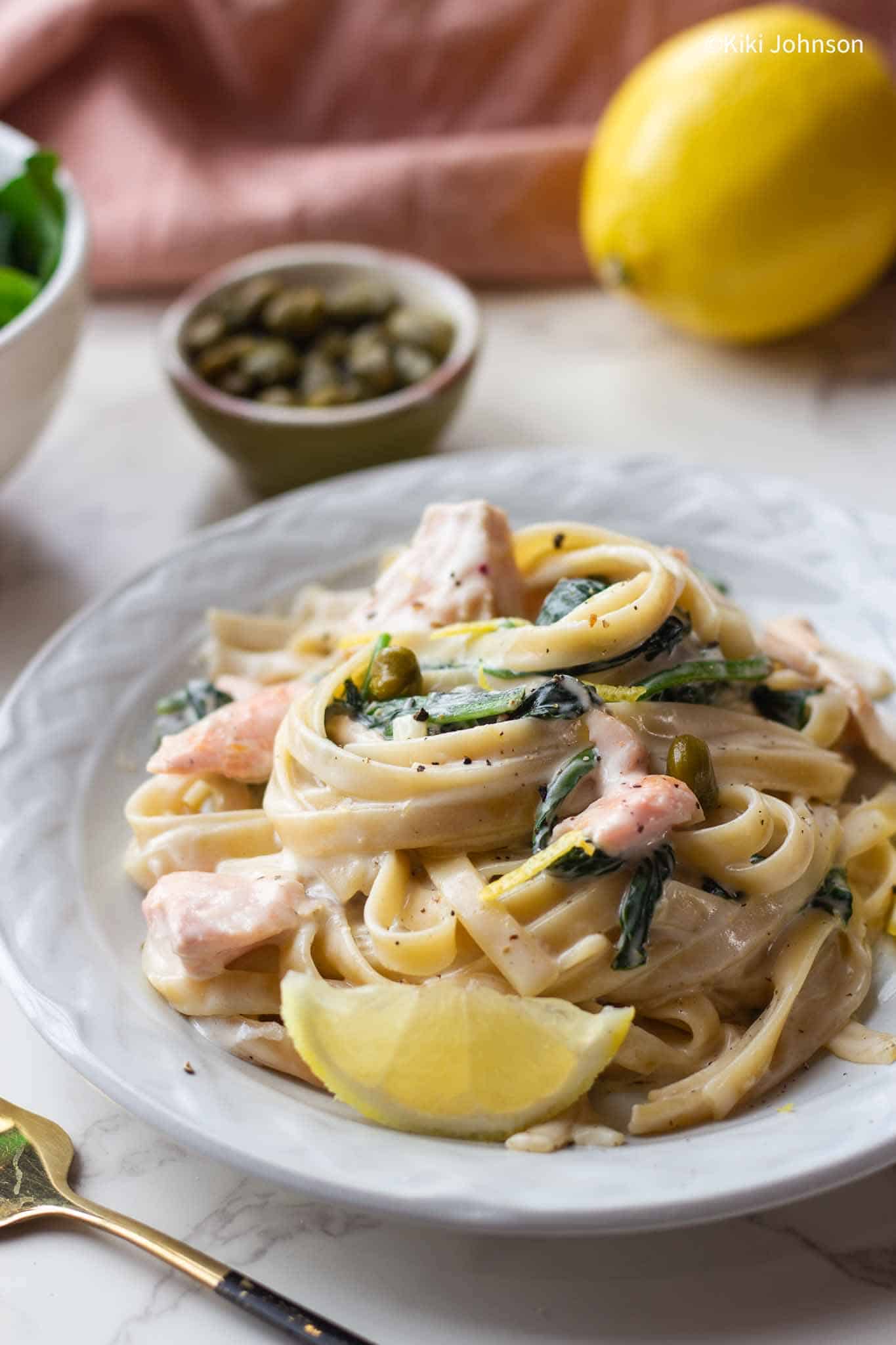 Ein Teller mit Nudeln mit Lachs und Spinat in Weißweinsoße 