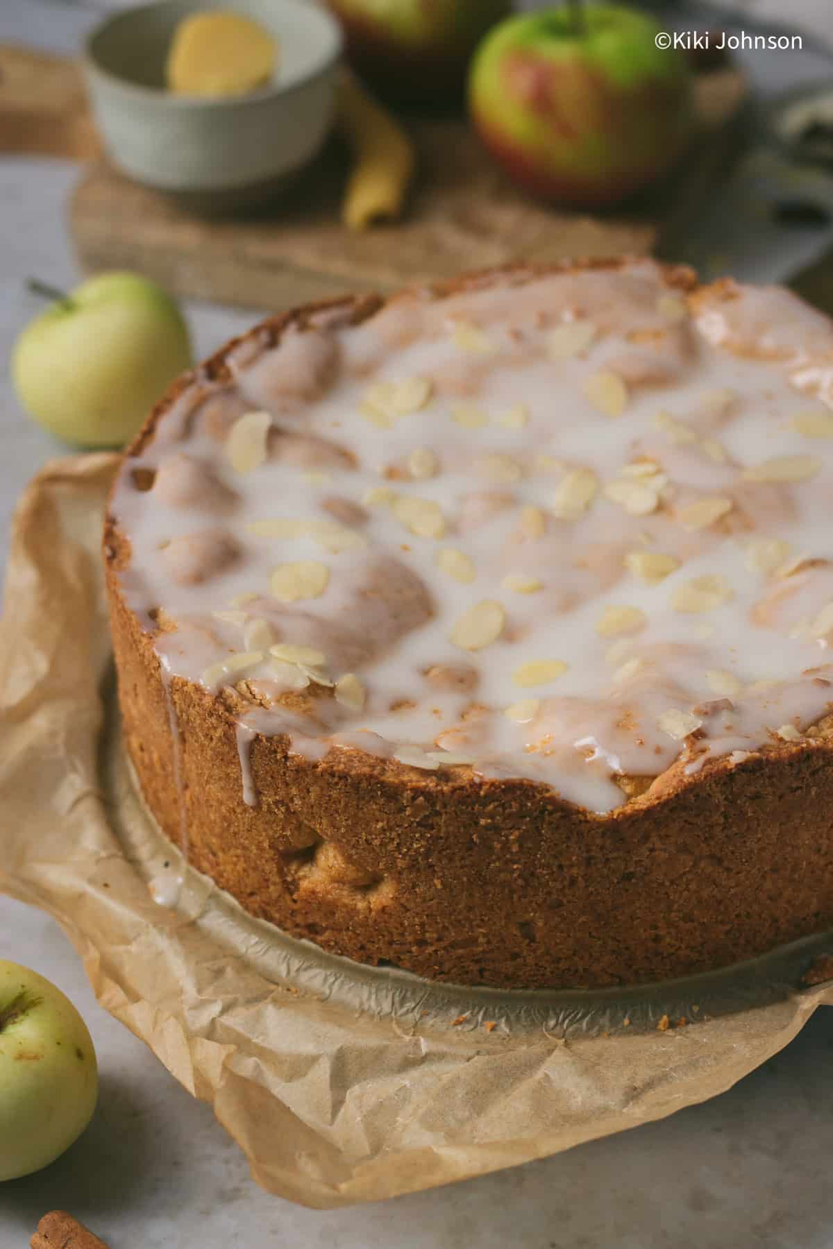 a whole German Apple Cake covered with lemon glaze and slivered almonds.