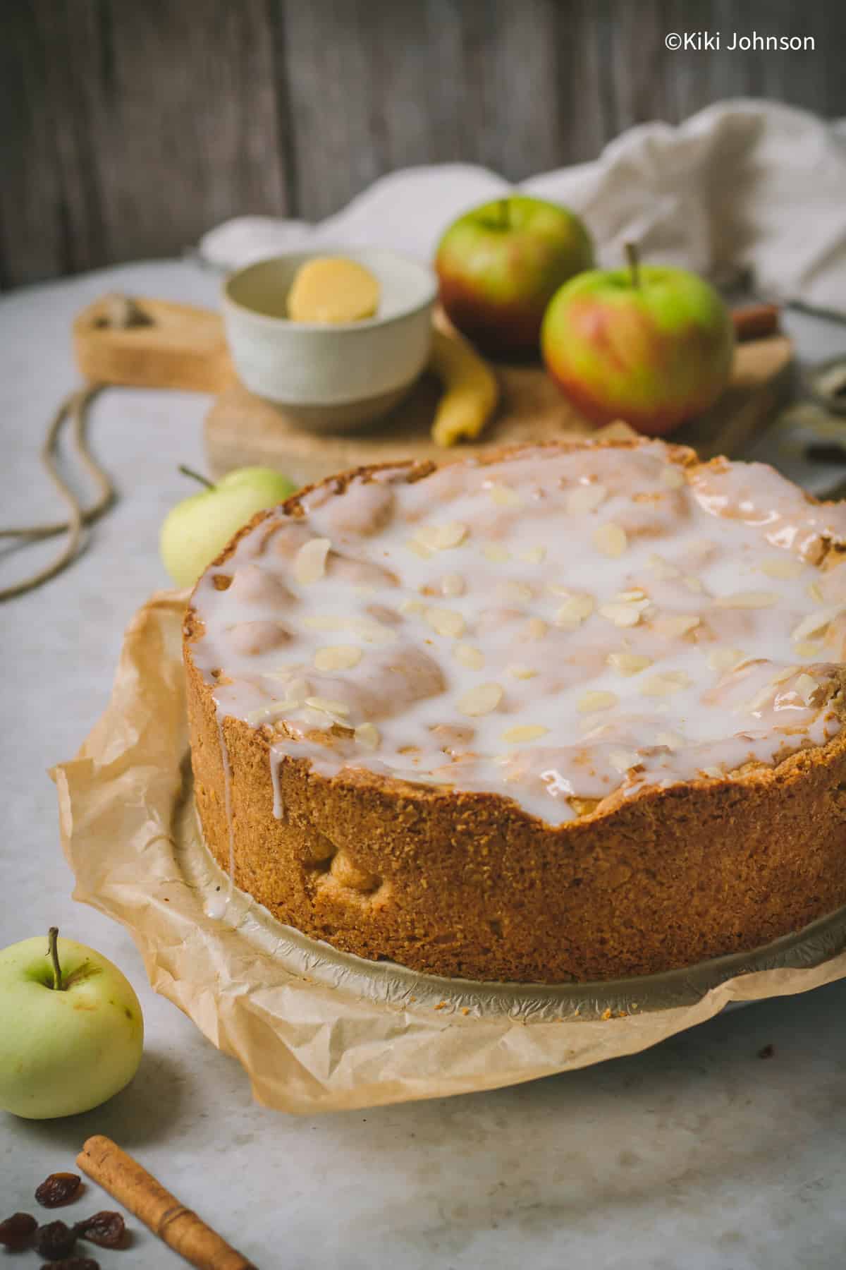 ein ganzer gedeckter Apfelkuchen mit Zuckerguss und Mandelblättchen. 