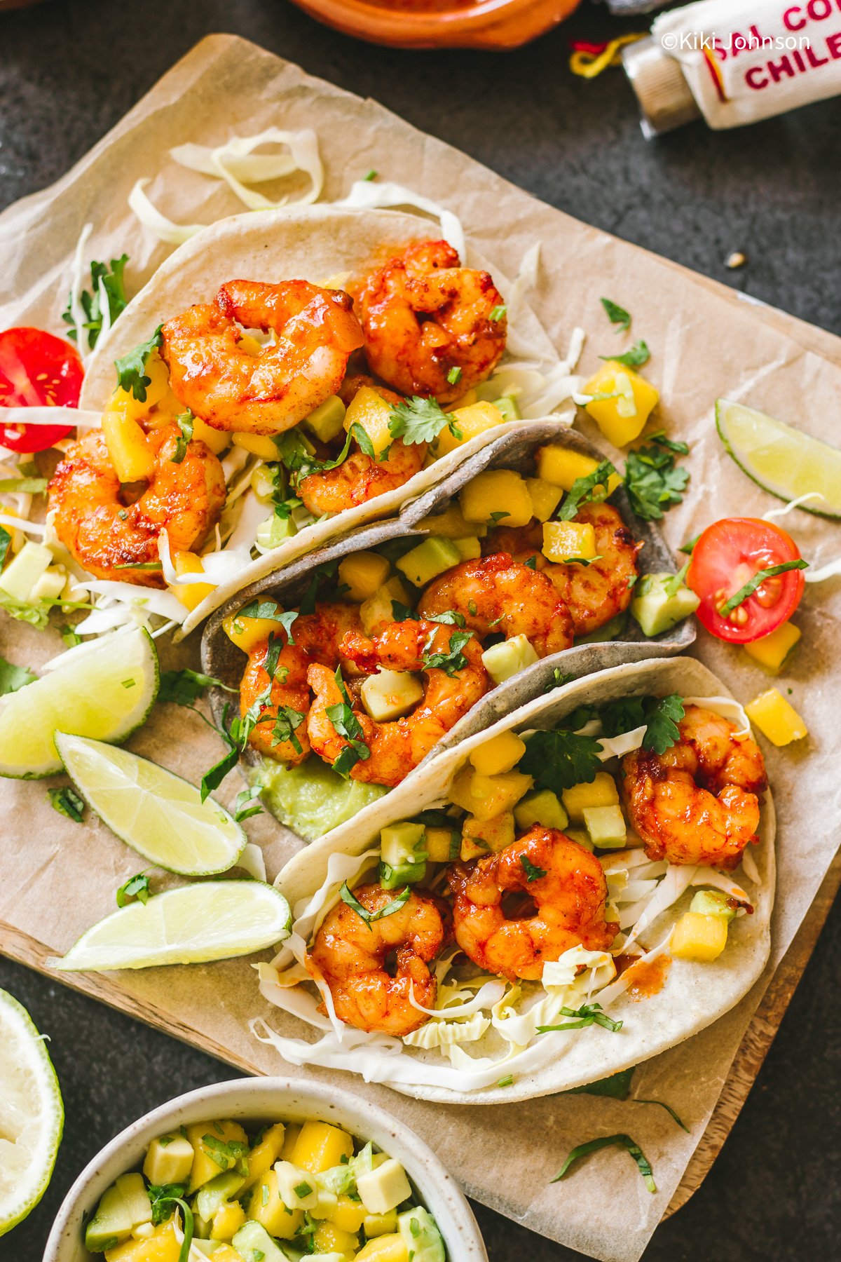 drei Garnelen Tacos mit Mango Avocado Salsa und frischen Koriander bestreut 