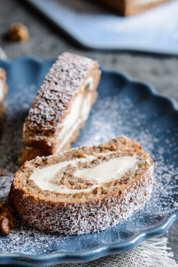 2 slices of Mary Berry walnut and coffee swiss roll on a blue plate