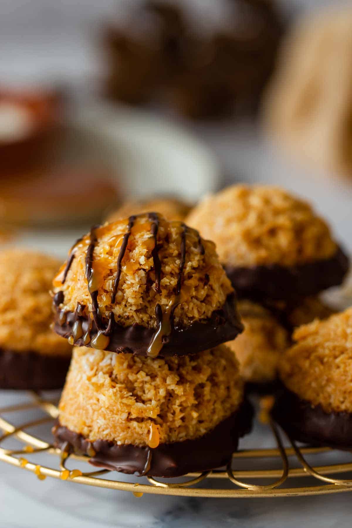 two no bake dulce de leche coconut macaroons with dark chocolate on a cooling rack 