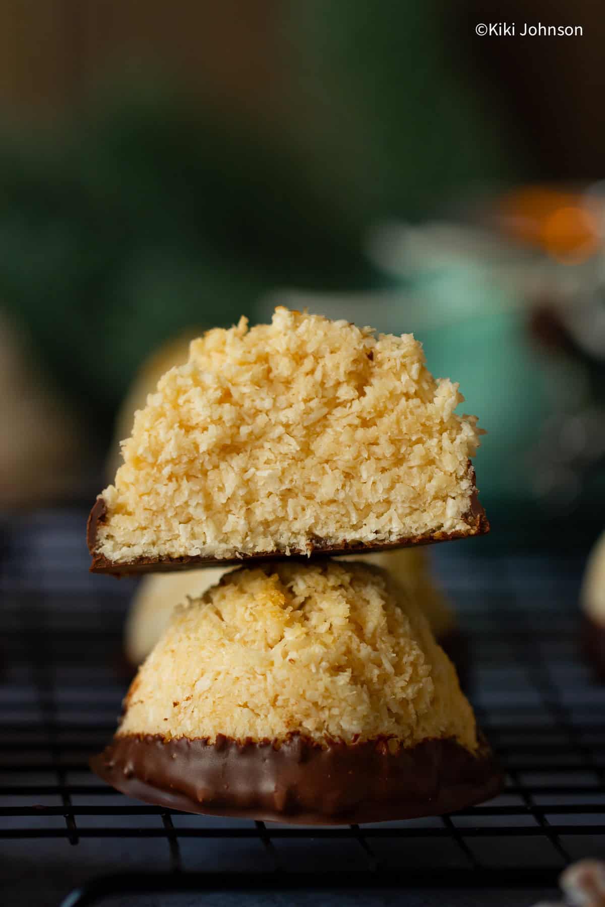 two chocolate dipped coconut macaroons with salted caramel stacked 