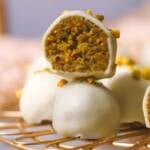 zwei Pistazien Pralinen mit weißer Schokolade übereinander mit einer angebissen.