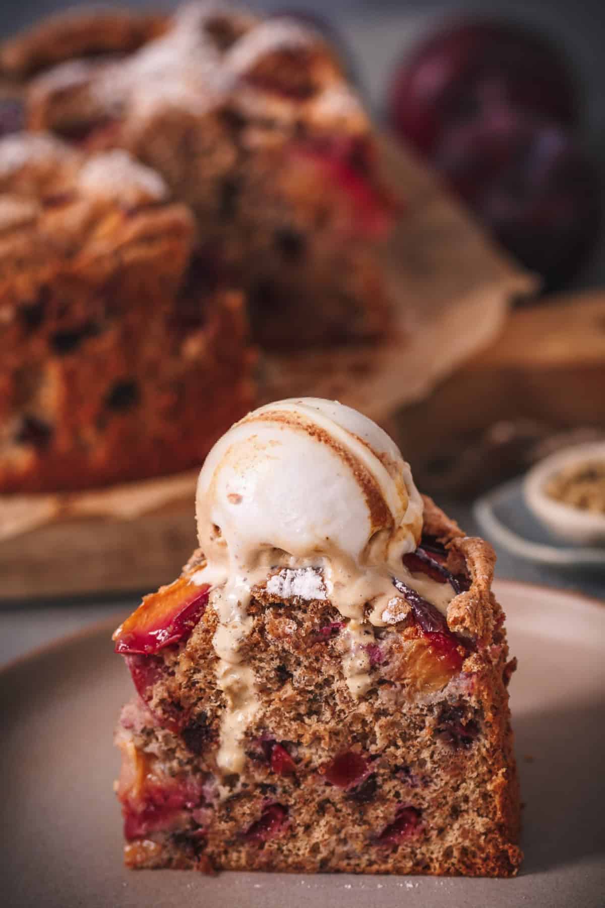 a slice of German Walnut Cake with Plums and Chocolate chips topped with walnut ice cream