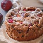 einfacher Walnusskuchen mit Pflaumen und Schokostückchen auf einem Stück Backpapier