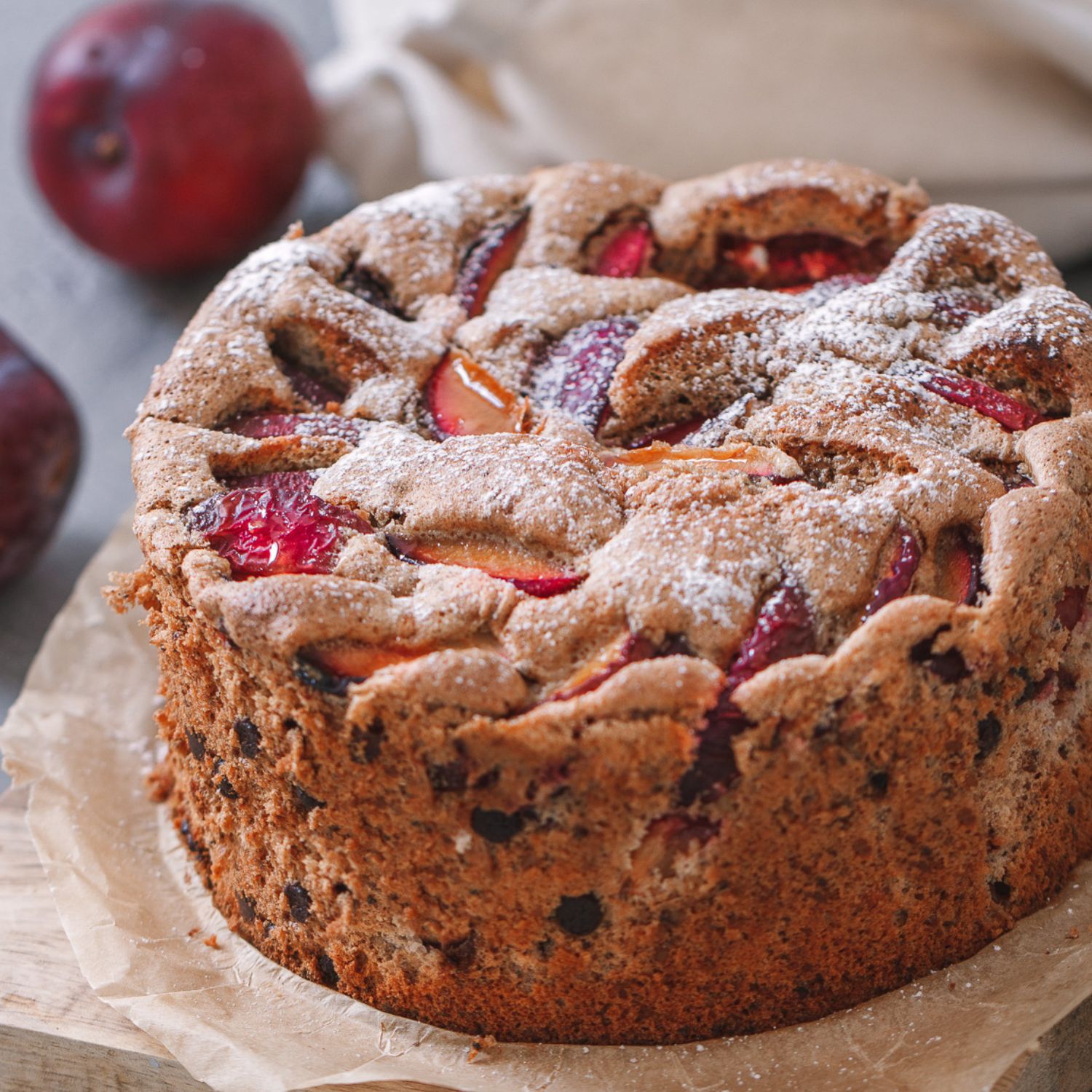 einfacher Walnusskuchen mit Pflaumen und Schokostückchen auf einem Stück Backpapier