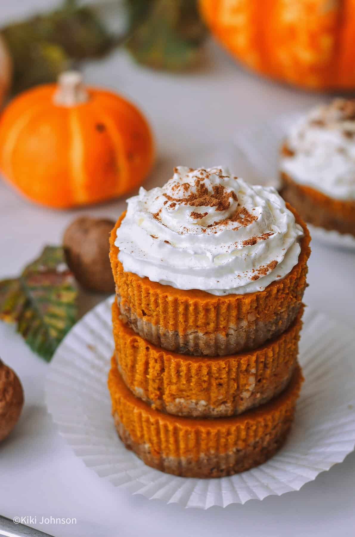 drei Kürbis Cupcakes mit Spekulatius-Haselnuss-Boden und cremiger Pumpkin-Spice-Füllung dekoriert mit Sahnehaube