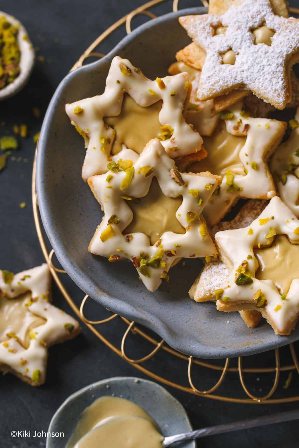 pistazien plätzchen mit pistaziencreme gefüllt auf einem blauen keksteller