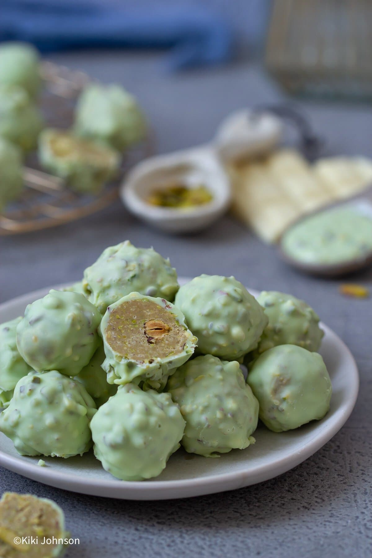 selbstgemachte Pistazien Rocher Pralinen auf einem kleinen weißen Keks Teller