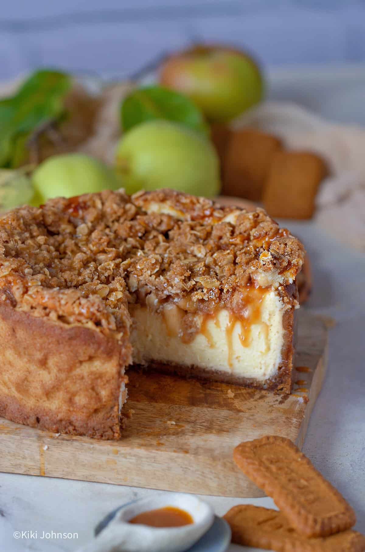 ein angeschnittener Apfel Käsekuchen mit Keksboden und Haferflocken Streusel