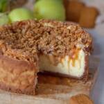 Der beste Apfel Käsekuchen mit Streusel und Keksboden angeschnitten auf einem Holzbrett