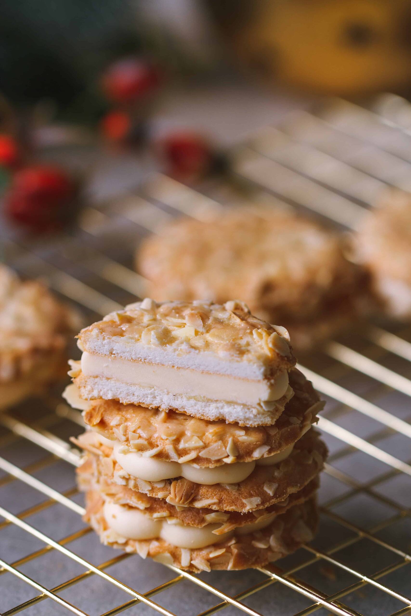 drei Bienenstich Plätzchen auf einem goldenen Plätzchen Gitter eines davon aufgeschnitten