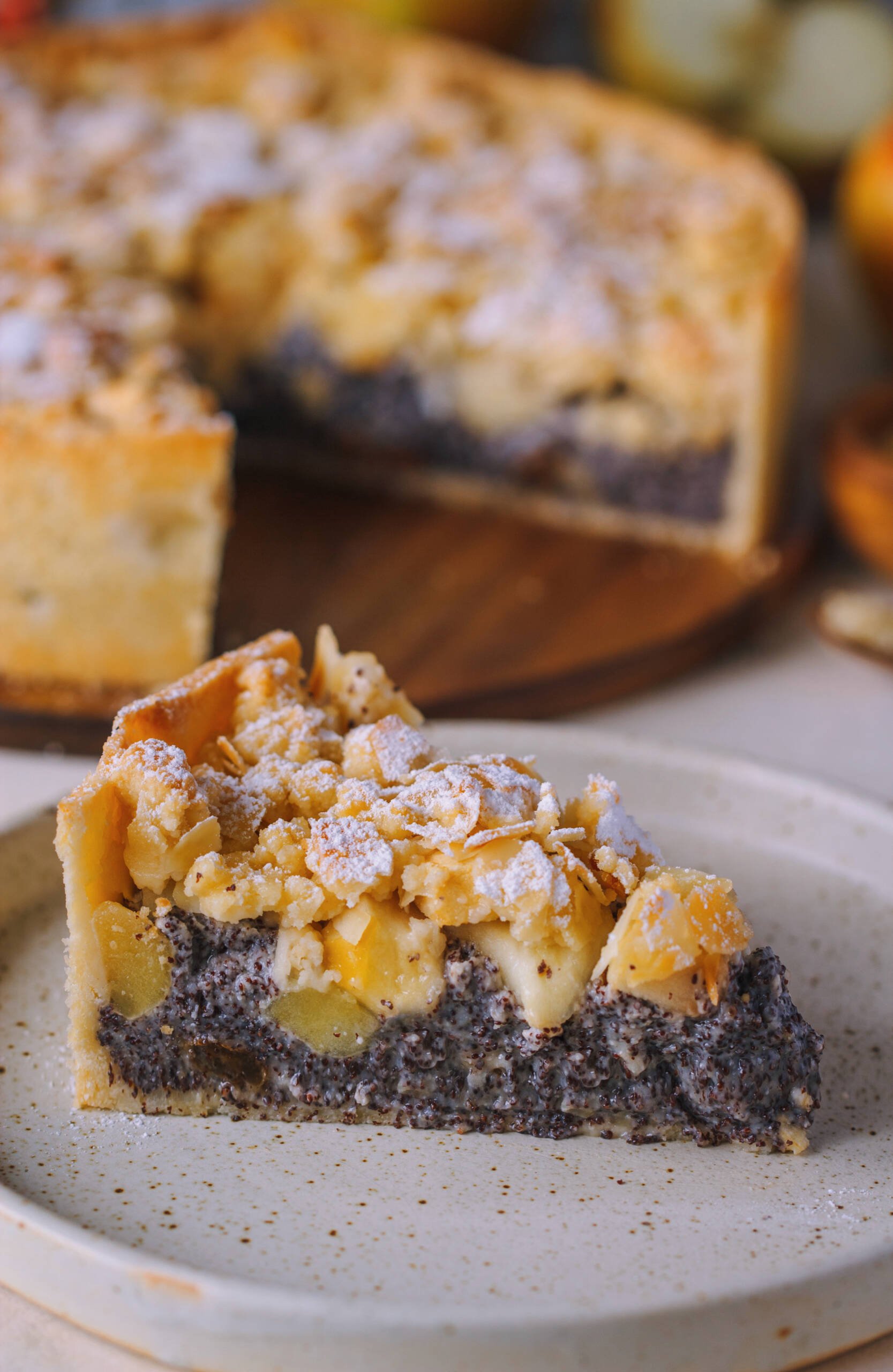 ein Stück  Apfel Mohnkuchen mit Mandel Streuseln auf einem weissen Teller