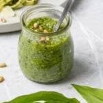 ein Glas Bärlauch Pesto auf Marmor Untergrund