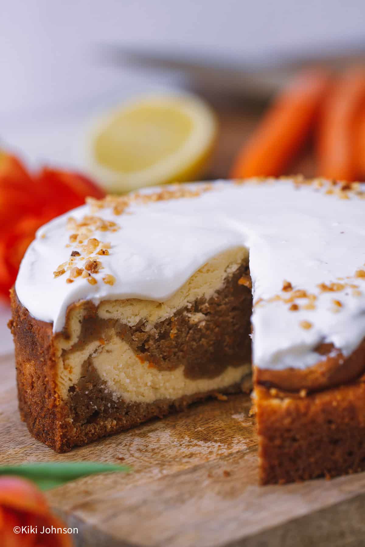 angeschnittener Carrot Cake Cheesecake auf einem Holzbrett