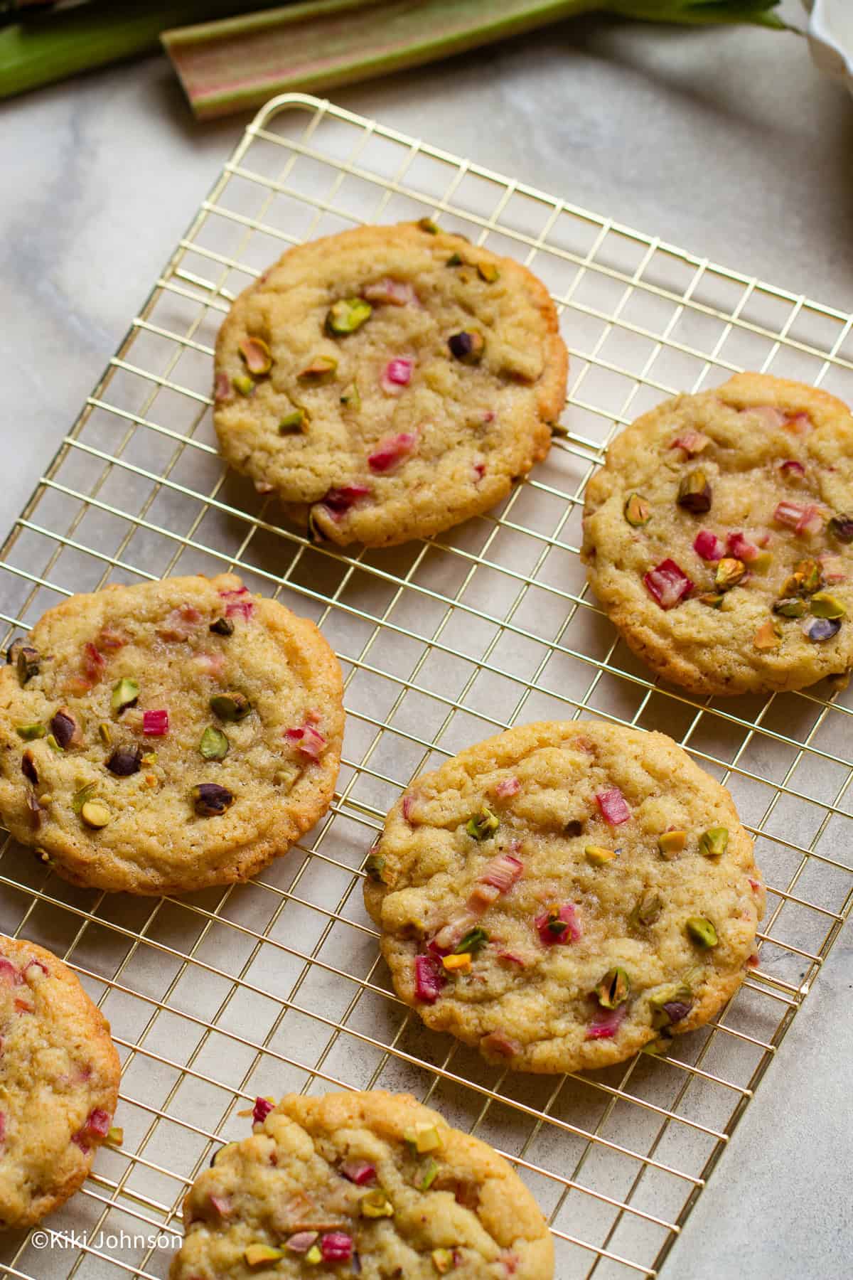 Rhabarber Cookies mit Pistazien auf einem goldenen Keksegitter 