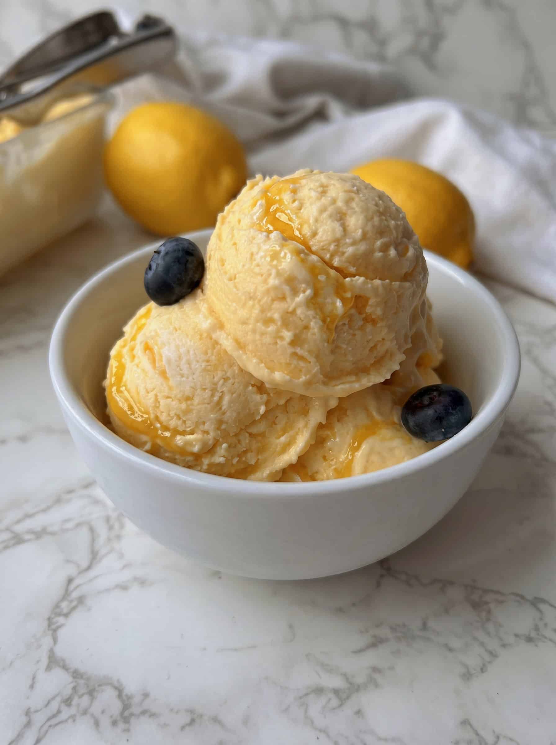 zwei Kugeln Lemon Curd Eis mit Lemon Curd Swirl in einer kleinen weissen Schale