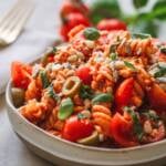 nudelsalat mit pesto, tomaten, oliven und feta in einer schale