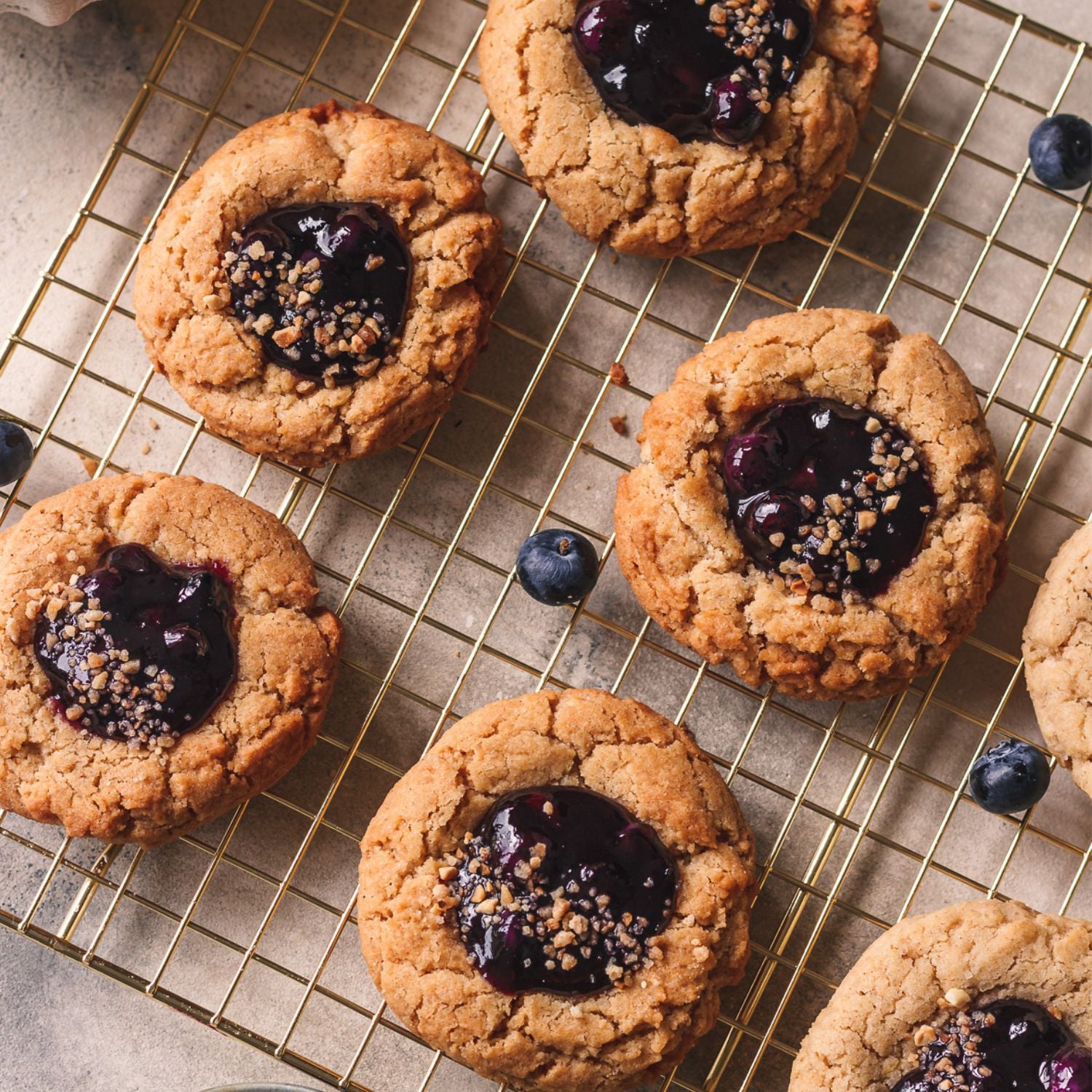blueberry pie cookies with blueberry jam filling on a golden rack